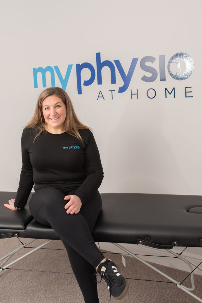 physio stephanie horn sitting on plinth infront of My Physio At Home logo